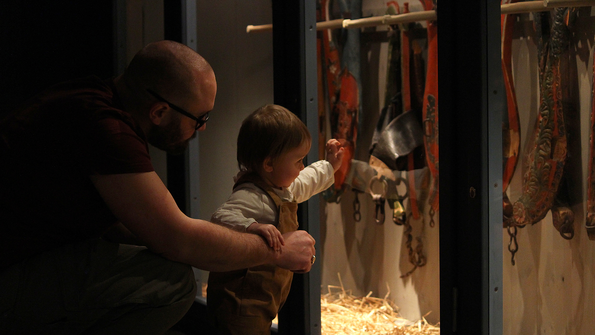En pappa och et barn som tittar på kulturhistoriska föremål