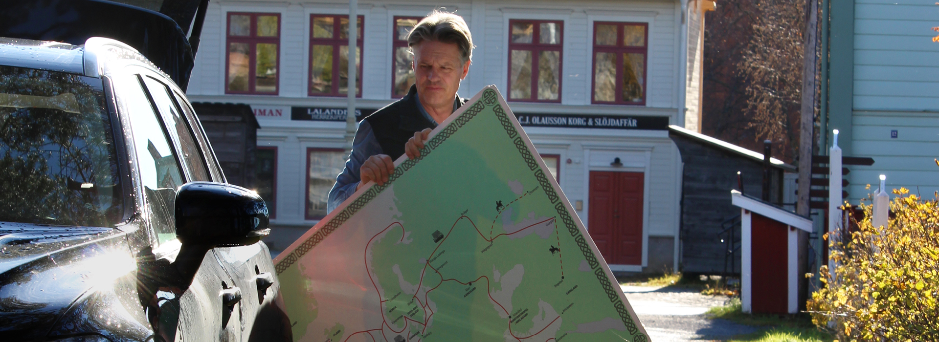 En person packar in en stor papp-karta i en bil